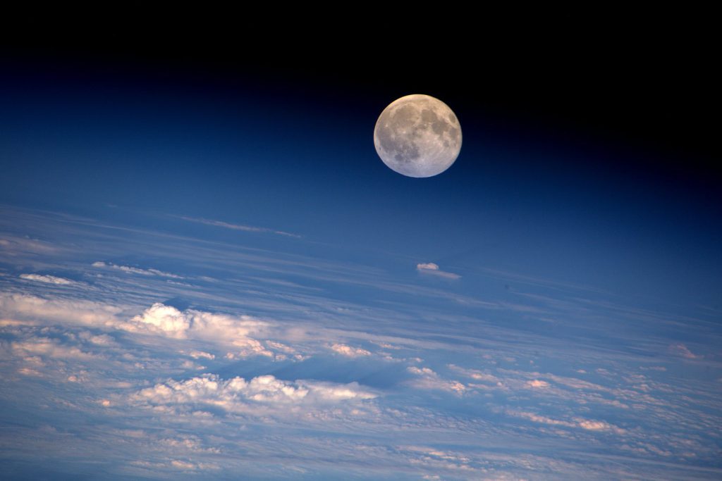 An amazing view of the full moon rising above a bed of clouds, as seen from the International Space Station