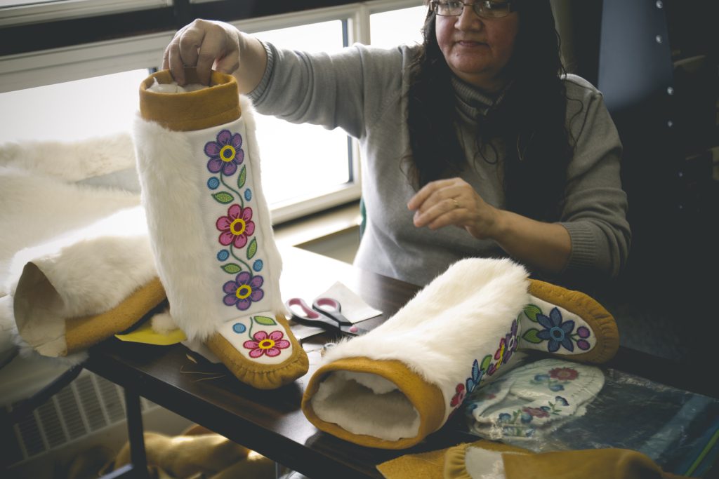 A Cree artist from Manitoba displays a pair of mukluks she created by hand