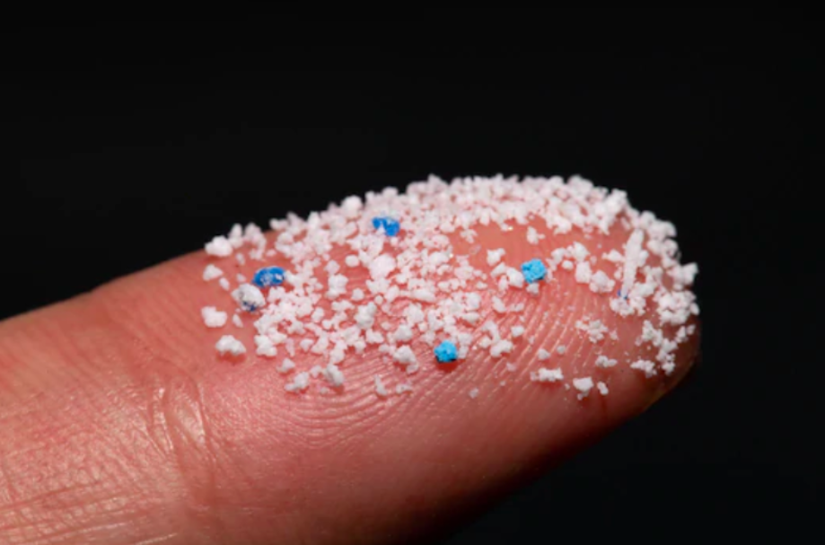 Tiny plastic particles on a fingertip