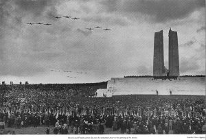 British and French airmen fly over the monument prior to the opening of the service